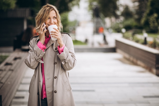 Giovane donna che beve caffè fuori in città