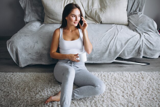 Giovane donna che beve il caffè a casa