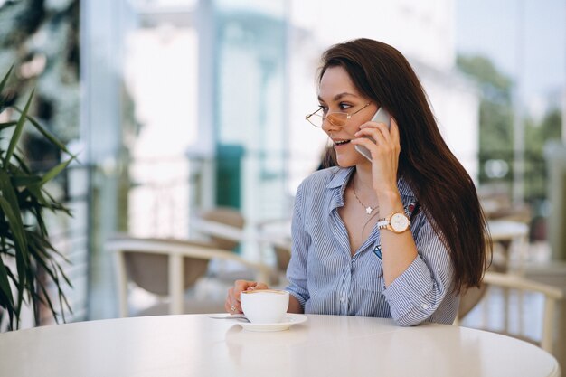 Giovane donna che beve il tè in un caffè