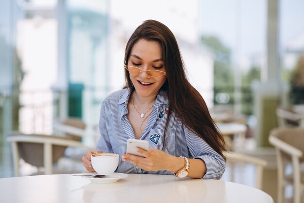 Giovane donna che beve il tè in un caffè