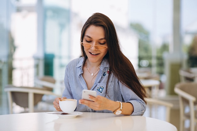 Giovane donna che beve il tè in un caffè