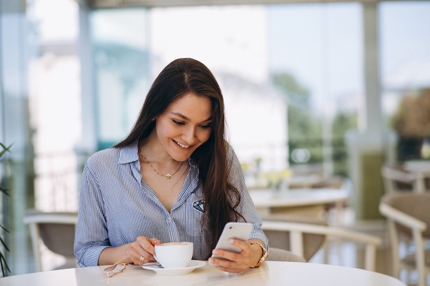 Giovane donna che beve il tè in un caffè