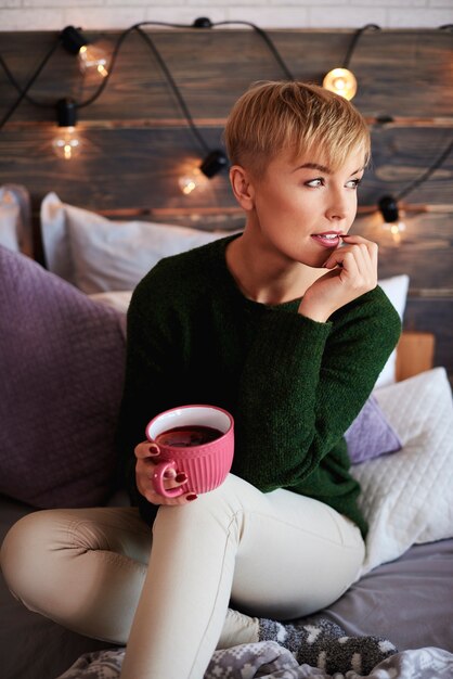 Giovane donna che beve il tè nella giornata invernale