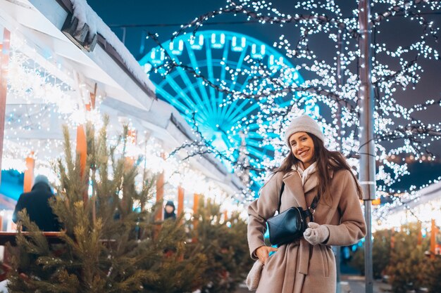 Giovane donna che cammina sul mercato con alberi