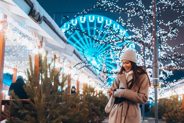 Giovane donna che cammina sul mercato con alberi