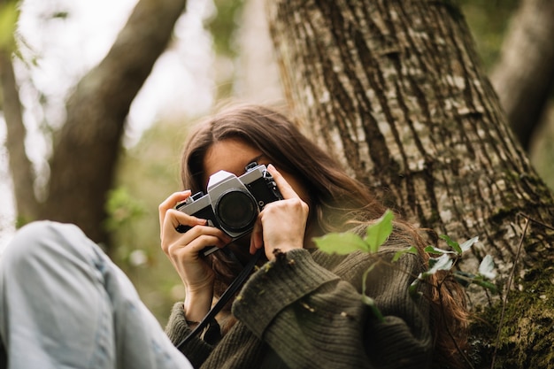 Giovane donna che cattura foto in natura