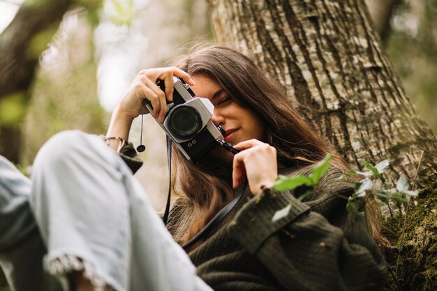 Giovane donna che cattura foto in natura