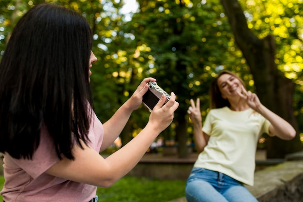 Giovane donna che cattura una foto della sua amica