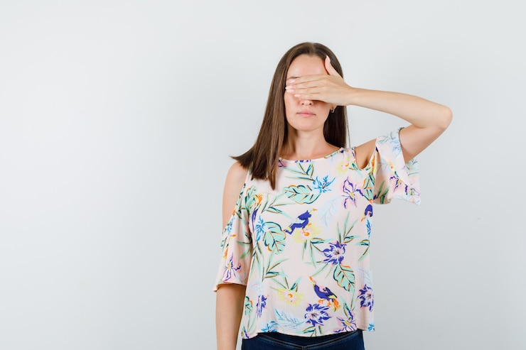 Foto gratuito giovane donna che copre gli occhi con la mano in camicia, jeans vista frontale.