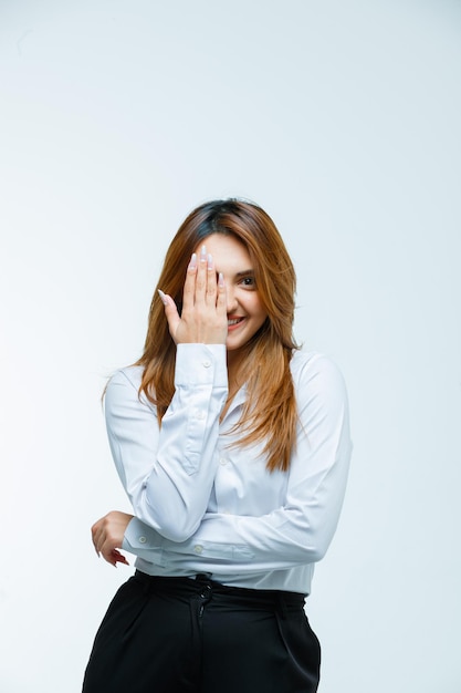 Giovane donna che copre l'occhio con la mano e sembra felice