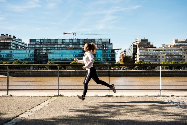 Giovane donna che corre all&#39;aperto con abiti sportivi