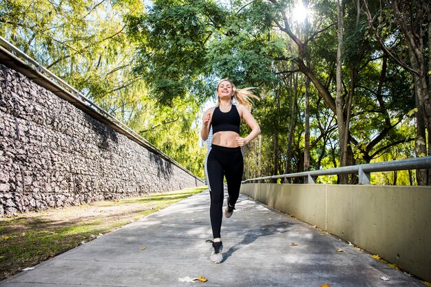 Giovane donna che corre all&#39;aperto con abiti sportivi