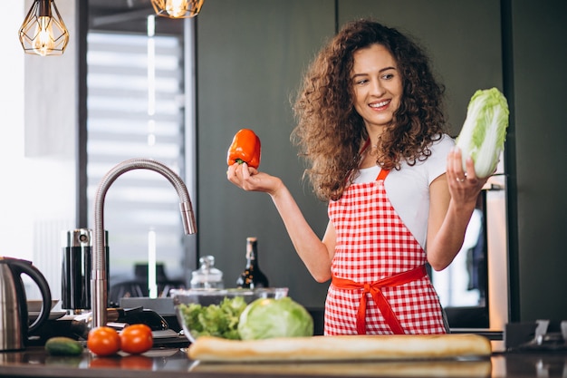 Giovane donna che cucina alla cucina