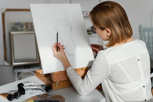 Giovane donna che disegna su una tela