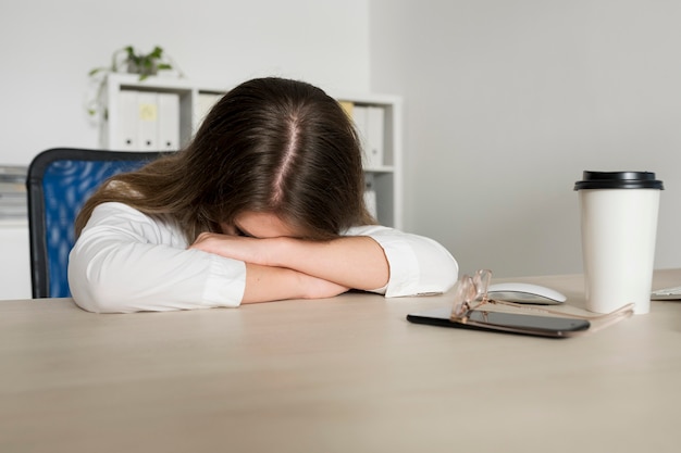 Giovane donna che dorme al lavoro