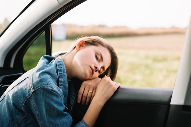 Giovane donna che dorme in auto