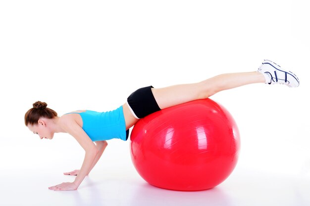 Giovane donna che fa ginnastica con fitball