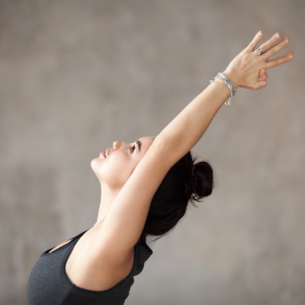 Giovane donna che fa l&#39;esercizio di Virabhadrasana 1