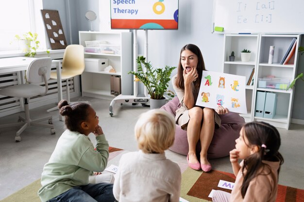 Giovane donna che fa logopedia con i bambini