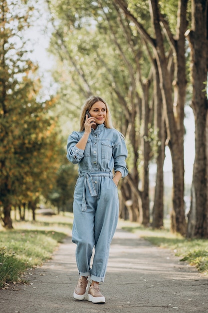 Giovane donna che fa shopping online nel parco