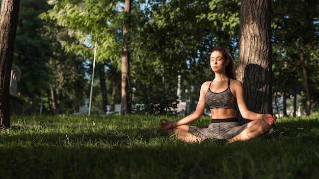 Giovane donna che fa sport nel parco