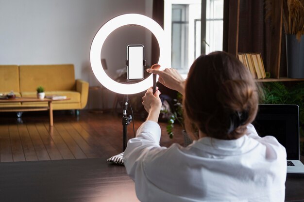 Giovane donna che fa un vlog di trucco con il suo smartphone