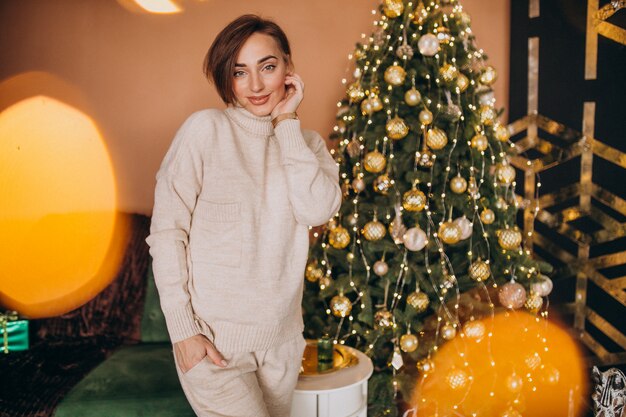 Giovane donna che fa una pausa l'albero di Natale