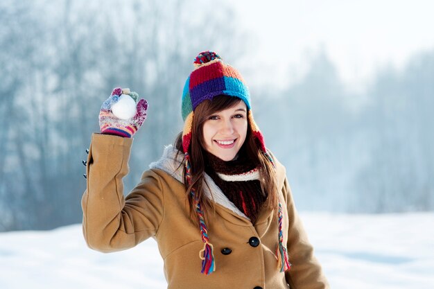 Giovane donna che getta palla di neve