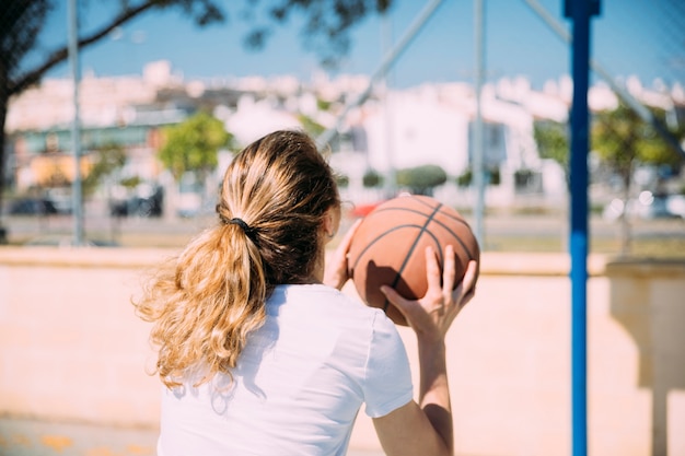 Giovane donna che gioca a basket