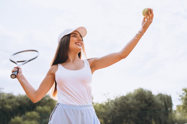 Giovane donna che gioca a tennis alla corte