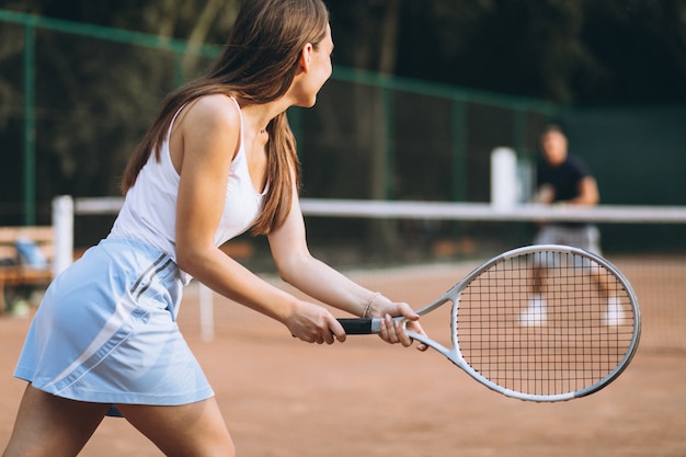 Giovane donna che gioca a tennis alla corte