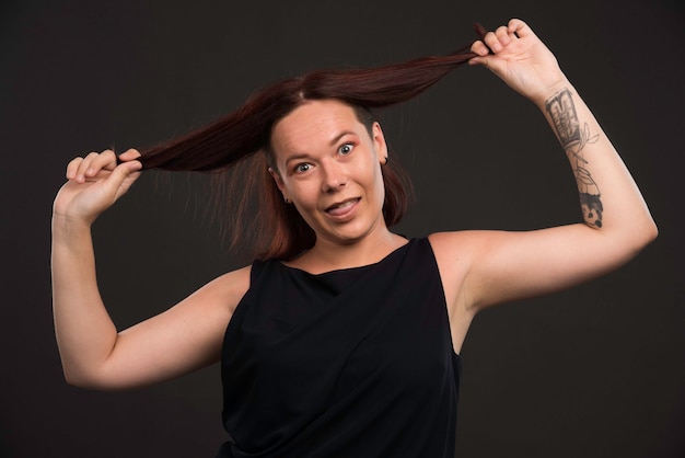 Giovane donna che gioca con i suoi capelli.