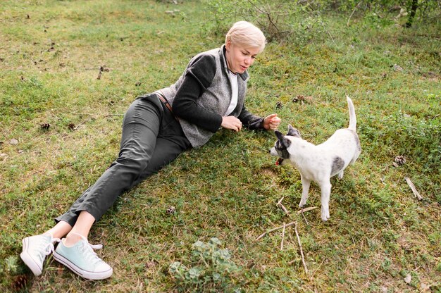 Giovane donna che gioca con il suo cane all'aperto