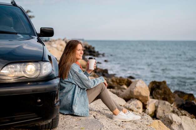 Giovane donna che gode del viaggio su strada