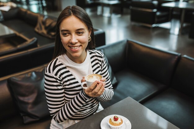 Giovane donna che gode di una tazza di caffè