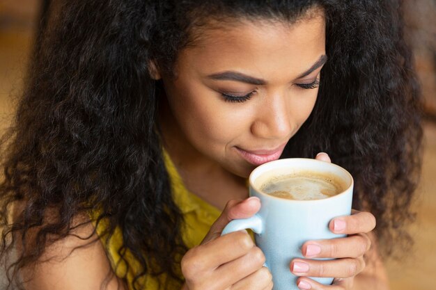 Giovane donna che gode di una tazza di caffè
