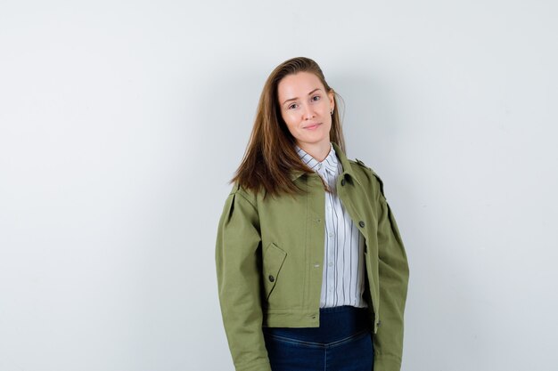 Giovane donna che guarda l'obbiettivo in camicia, giacca e sembra affascinante. vista frontale.