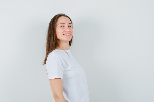 Giovane donna che guarda l'obbiettivo in t-shirt bianca e sembra elegante