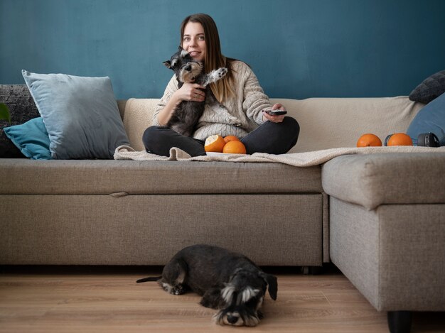 Giovane donna che guarda la tv con i suoi cani