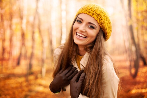 Giovane donna che indossa abiti autunnali ridendo nel parco