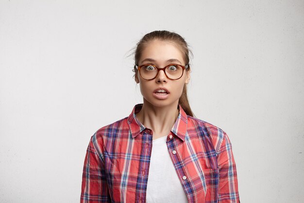 Giovane donna che indossa camicia a righe e occhiali da vista