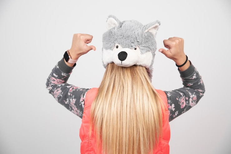 Foto gratuito giovane donna che indossa un cappello divertente su un muro bianco.