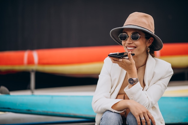 Giovane donna che indossa un cappello e utilizzando il telefono