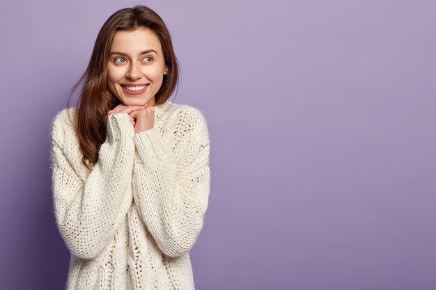 Giovane donna che indossa un maglione bianco