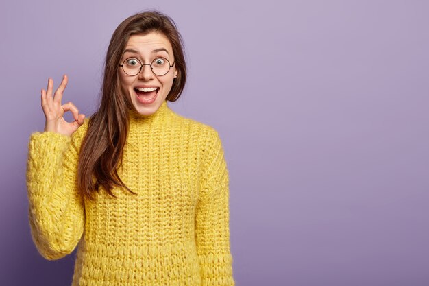 Giovane donna che indossa un maglione giallo