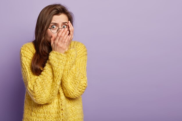 Giovane donna che indossa un maglione giallo