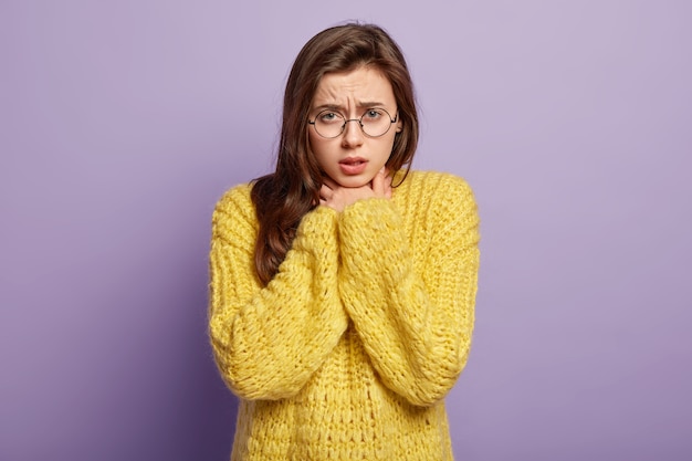 Giovane donna che indossa un maglione giallo