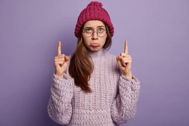 Giovane donna che indossa un maglione viola e cappello