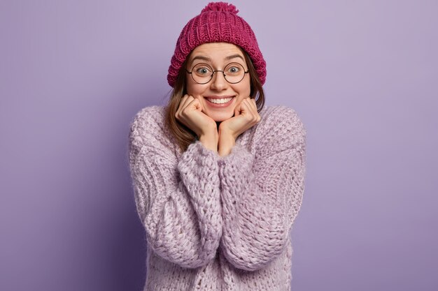 Giovane donna che indossa un maglione viola e cappello