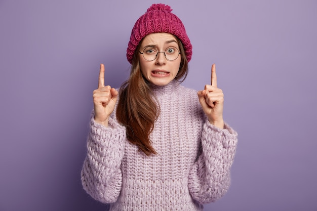 Giovane donna che indossa un maglione viola e cappello